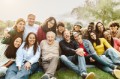 Happy multigenerational people having fun sitting on grass in a public park - People diversity concept
Familie