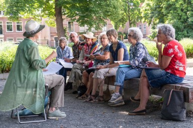 Groep schrijvende personen in het park